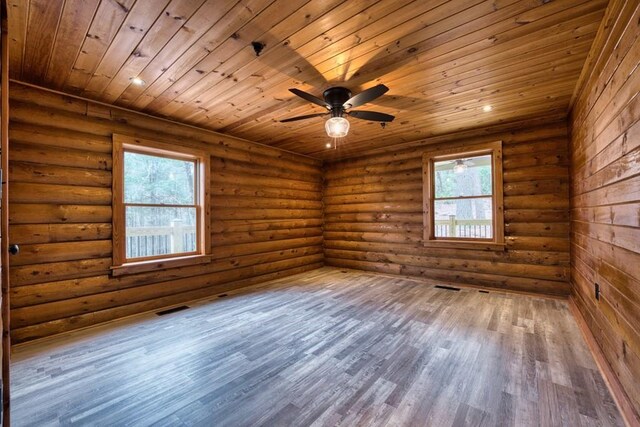 unfurnished room with wood ceiling, plenty of natural light, wood finished floors, and visible vents