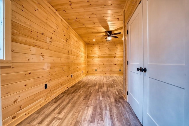 additional living space featuring wood walls, wood ceiling, a ceiling fan, and wood finished floors