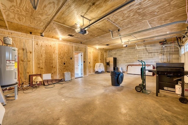 garage with a garage door opener, concrete block wall, water heater, and stainless steel fridge with ice dispenser