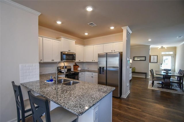 kitchen featuring sink, appliances with stainless steel finishes, ornamental molding, white cabinets, and kitchen peninsula