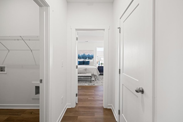 corridor featuring dark wood finished floors and baseboards