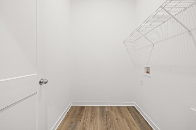 washroom featuring laundry area, hookup for a washing machine, baseboards, and wood finished floors