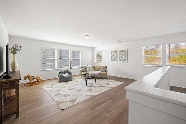 living area with baseboards and wood finished floors