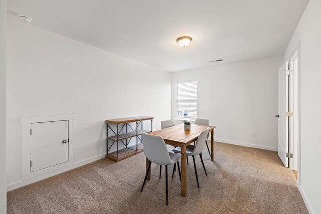 dining area with visible vents, light carpet, and baseboards