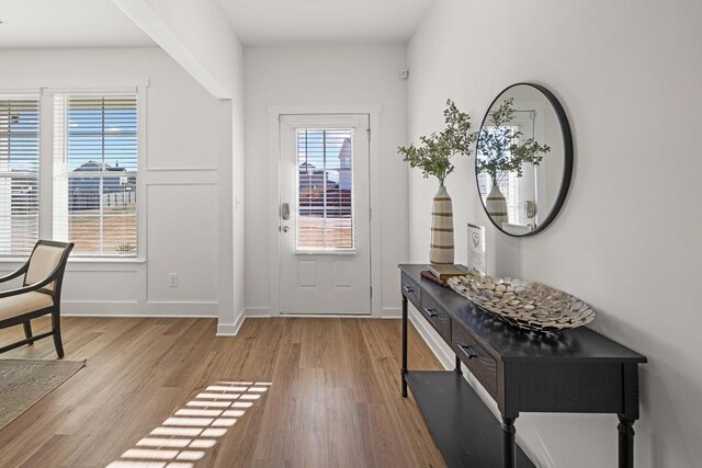 doorway with baseboards and light wood-style floors