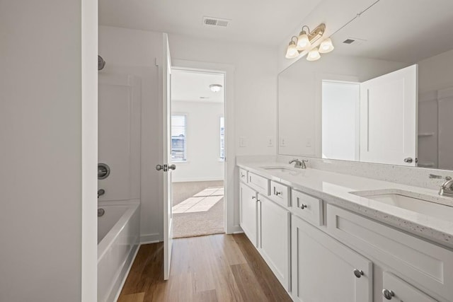 full bathroom with visible vents, wood finished floors, and a sink