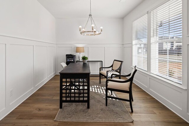 dining room featuring an inviting chandelier, dark wood finished floors, wainscoting, and a decorative wall