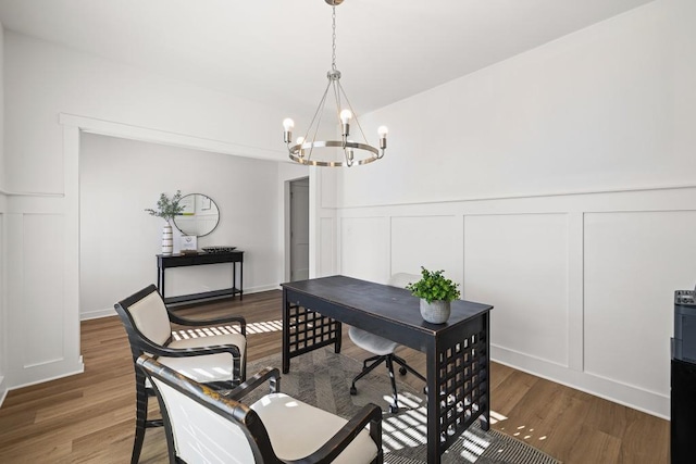 home office featuring an inviting chandelier, wood finished floors, wainscoting, and a decorative wall