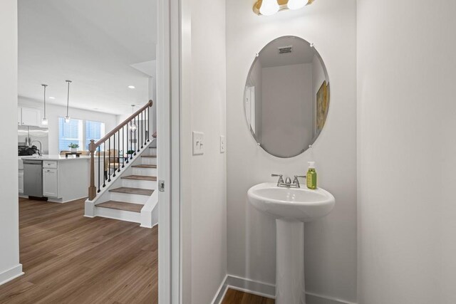 bathroom with a sink, recessed lighting, baseboards, and wood finished floors