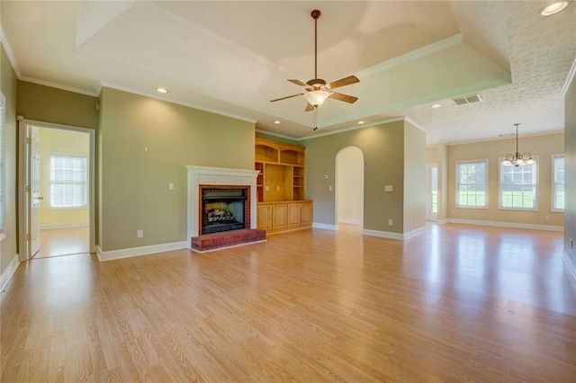 172 Lakeview Dr, Newborn, GA 30056 - unfurnished living room with light wood finished floors, a ceiling fan, a fireplace, ornamental molding, and arched walkways
