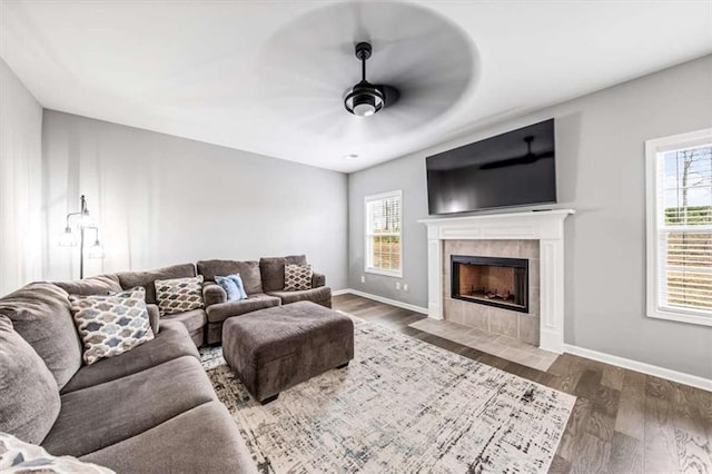 living room with a healthy amount of sunlight, ceiling fan, a fireplace, and wood finished floors