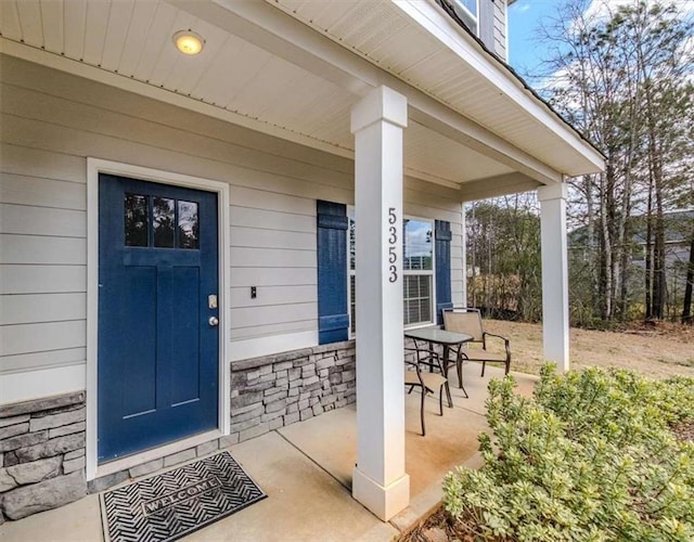 entrance to property with stone siding and covered porch