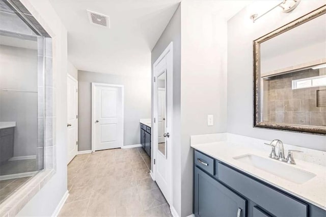 bathroom featuring two vanities, visible vents, a sink, baseboards, and walk in shower