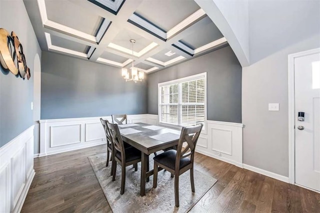 dining space with arched walkways, coffered ceiling, beamed ceiling, wood finished floors, and a chandelier