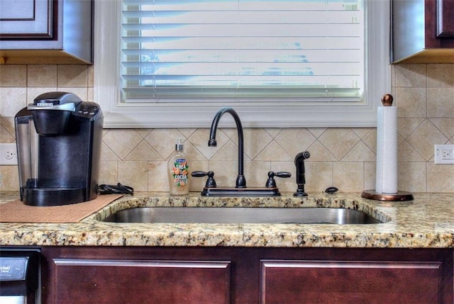 room details with decorative backsplash, light stone countertops, dishwasher, and sink