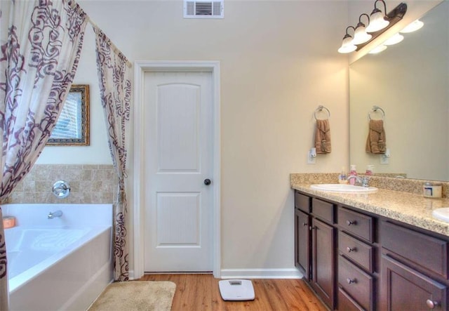 bathroom featuring hardwood / wood-style floors, vanity, and a bathtub