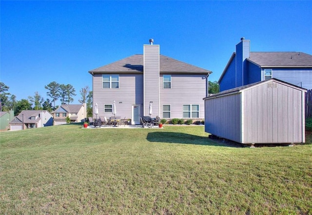 back of property with a storage shed, a yard, and a patio