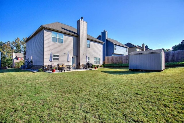 back of house with a lawn and a storage unit