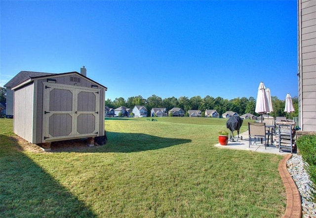 view of yard featuring a storage unit and a patio