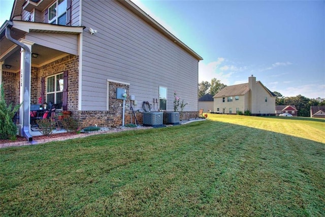 view of side of property featuring cooling unit and a lawn