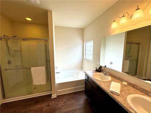 bathroom with wood-type flooring, independent shower and bath, and vanity