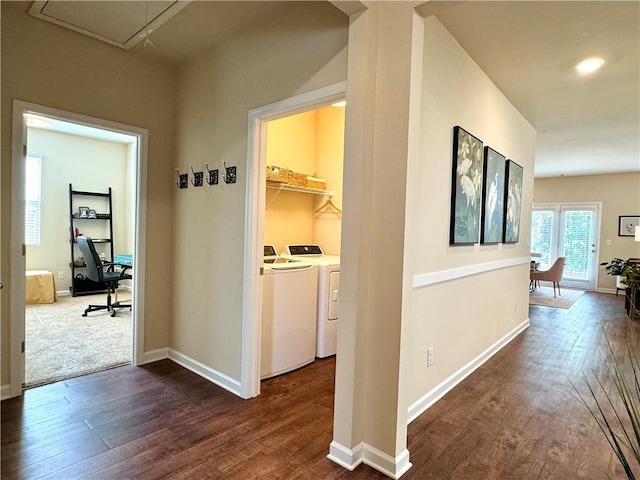 hallway with dark wood-type flooring and washing machine and dryer