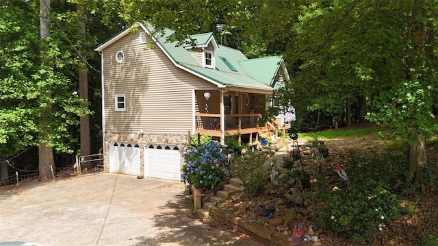 141 Mills Creek Path, Hiram, GA 30141 - view of side of home with concrete driveway, a garage, stone siding, and metal roof