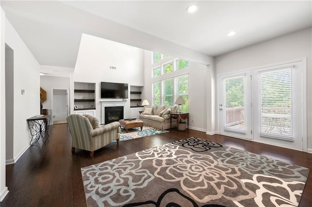 living room with visible vents, a glass covered fireplace, wood finished floors, baseboards, and recessed lighting
