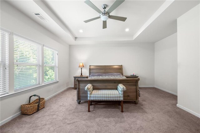 carpeted bedroom featuring a ceiling fan, visible vents, baseboards, a raised ceiling, and recessed lighting