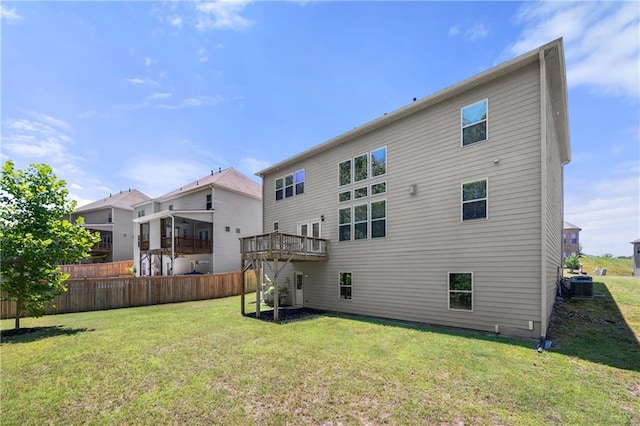 rear view of property featuring central air condition unit, fence, a lawn, and a deck