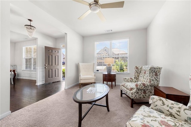 living area with carpet floors, a ceiling fan, baseboards, and visible vents