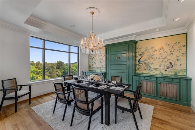 dining room with light wood-style floors, crown molding, a chandelier, and a tray ceiling