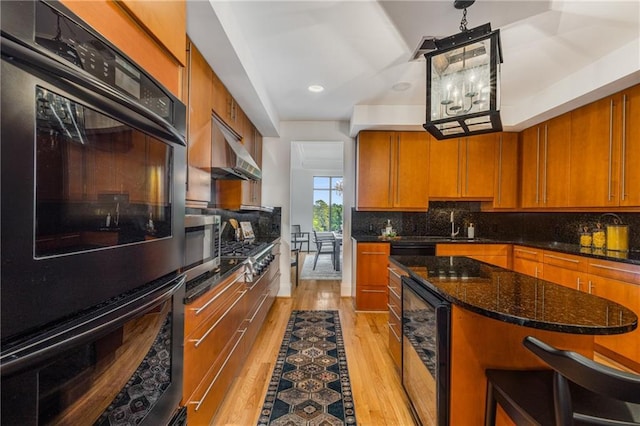 kitchen featuring backsplash, brown cabinetry, light wood finished floors, and wine cooler