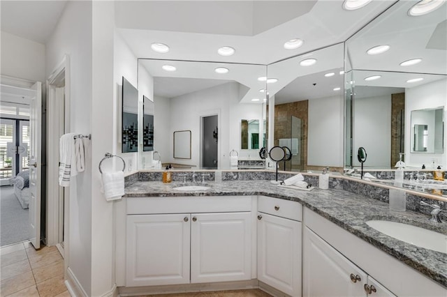 full bath with a sink, tile patterned flooring, recessed lighting, and double vanity