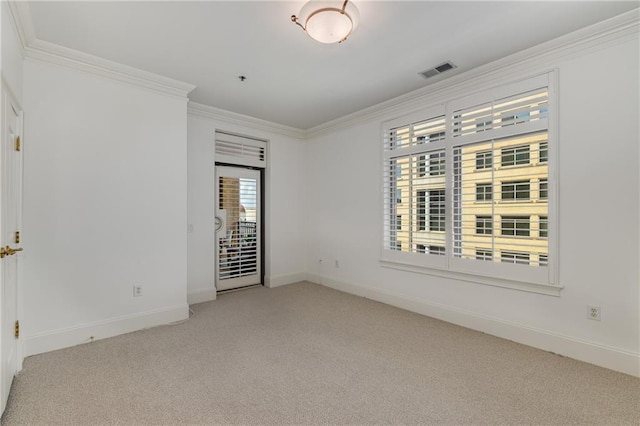carpeted spare room with baseboards, visible vents, and ornamental molding