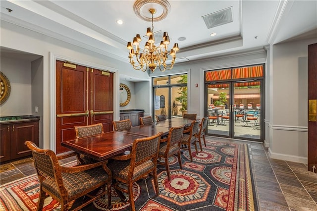 dining space featuring a raised ceiling, baseboards, a notable chandelier, and visible vents