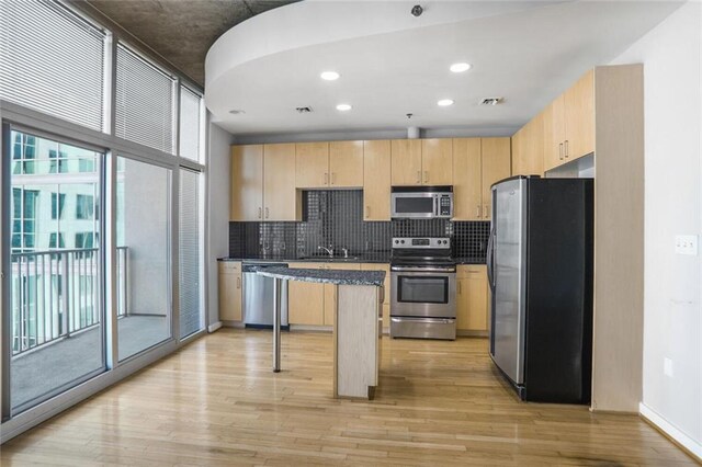 kitchen with light wood-style flooring, appliances with stainless steel finishes, and light brown cabinetry