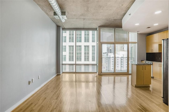 unfurnished living room with baseboards and light wood-style floors
