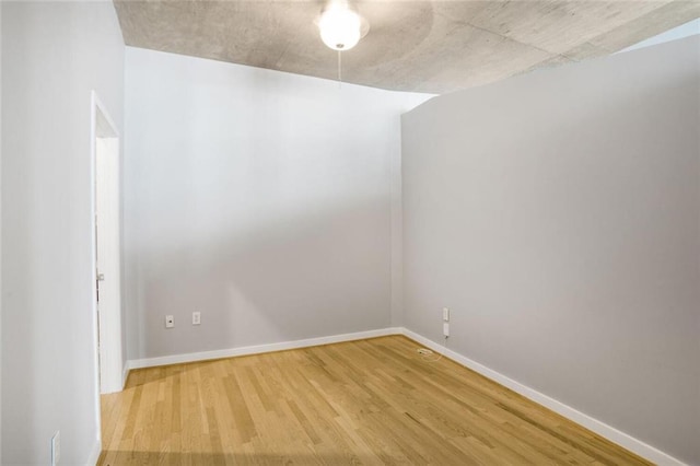 spare room featuring baseboards and light wood-style flooring