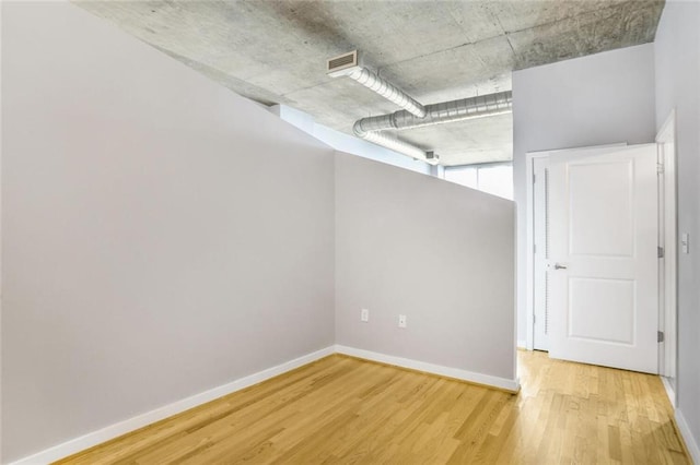 unfurnished room featuring baseboards, visible vents, and light wood-type flooring