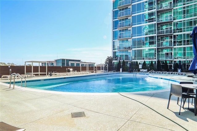 community pool featuring fence and a patio