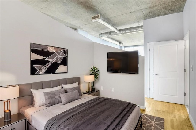 bedroom with visible vents, baseboards, and wood finished floors