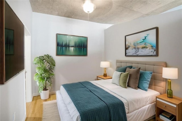 bedroom featuring baseboards and wood finished floors