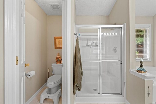 1865 Morgans Run Trl, Buford, GA 30519 - bathroom featuring toilet, a stall shower, baseboards, a textured ceiling, and tile patterned floors