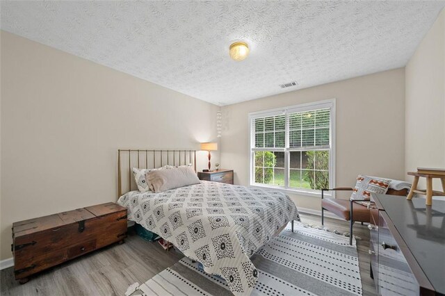1865 Morgans Run Trl, Buford, GA 30519 - bedroom with wood finished floors, a textured ceiling, and baseboards