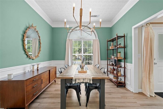 1865 Morgans Run Trl, Buford, GA 30519 - dining space with a chandelier, a textured ceiling, light wood-style floors, wainscoting, and crown molding