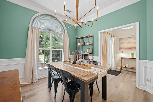 1865 Morgans Run Trl, Buford, GA 30519 - dining area with a wainscoted wall, a chandelier, a textured ceiling, crown molding, and wood finished floors