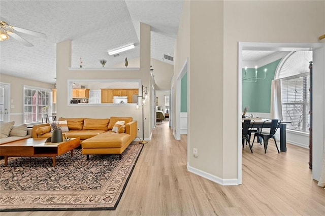 1865 Morgans Run Trl, Buford, GA 30519 - living area featuring light wood-style floors, a textured ceiling, baseboards, a ceiling fan, and lofted ceiling