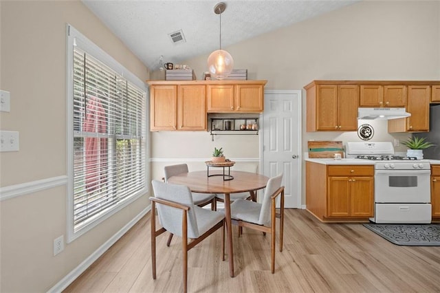 1865 Morgans Run Trl, Buford, GA 30519 - kitchen featuring white gas stove, under cabinet range hood, light wood finished floors, a textured ceiling, and light countertops