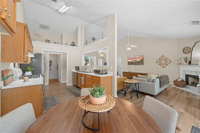 1865 Morgans Run Trl, Buford, GA 30519 - dining room with ceiling fan, light wood finished floors, a high end fireplace, a textured ceiling, and baseboards